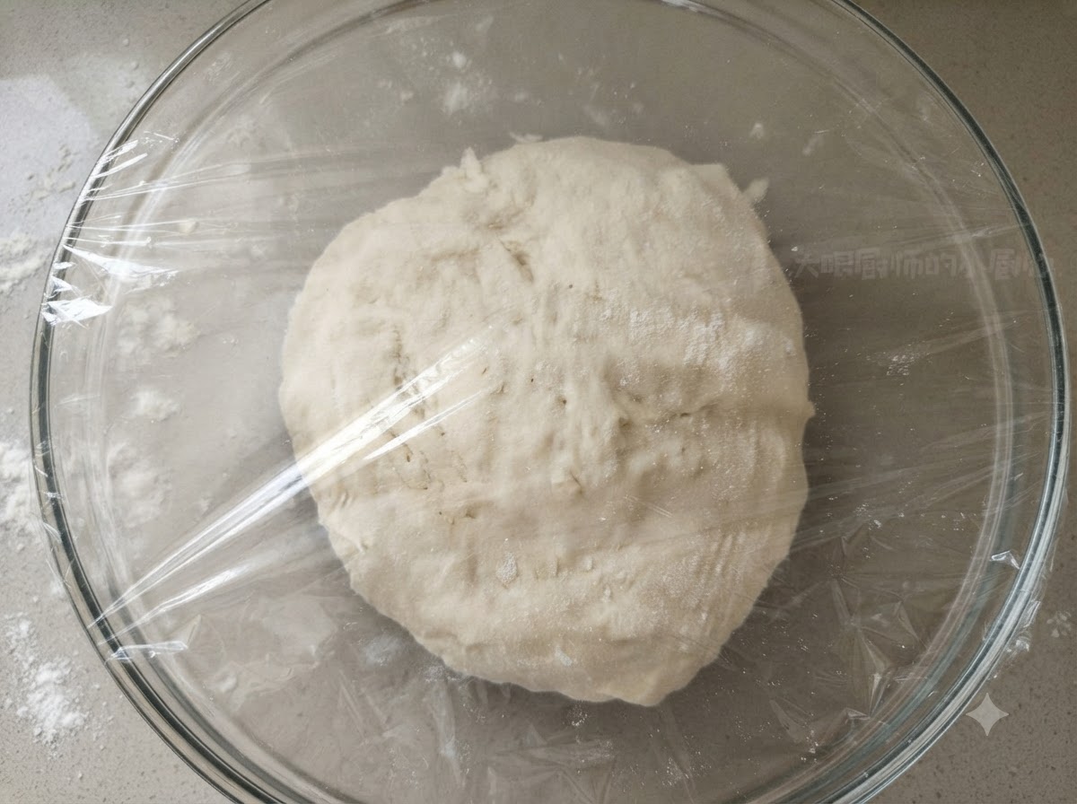 Une boule de pate lisse a linterieur dun bol en verre transparent recouvert hermetiquement de film plastique.