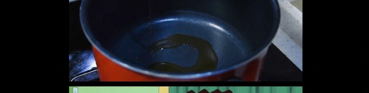 Une fine couche dhuile de sésame en train de chauffer au fond dune casserole sombre.