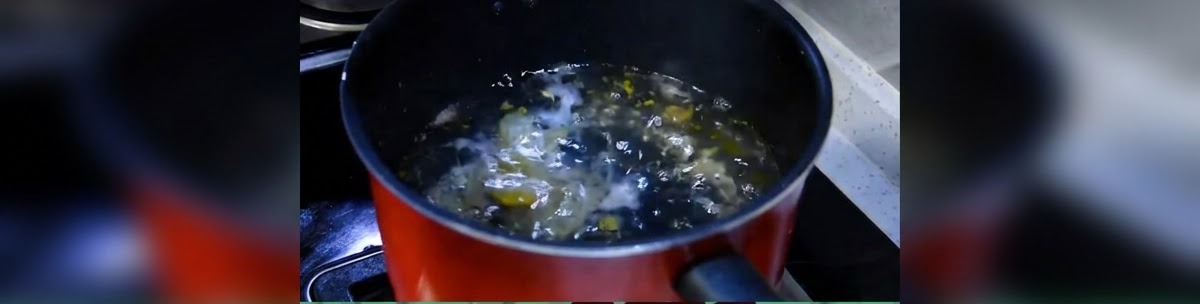 Une casserole sombre avec de leau qui commence à frémir doucement sur la cuisinière.