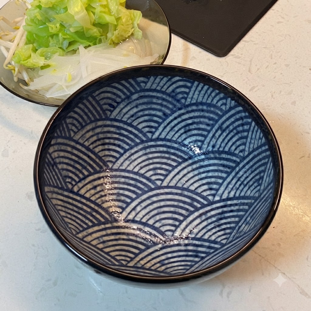Un bol de service à motifs bleus placé à côté dune assiette de légumes disposés en couches.