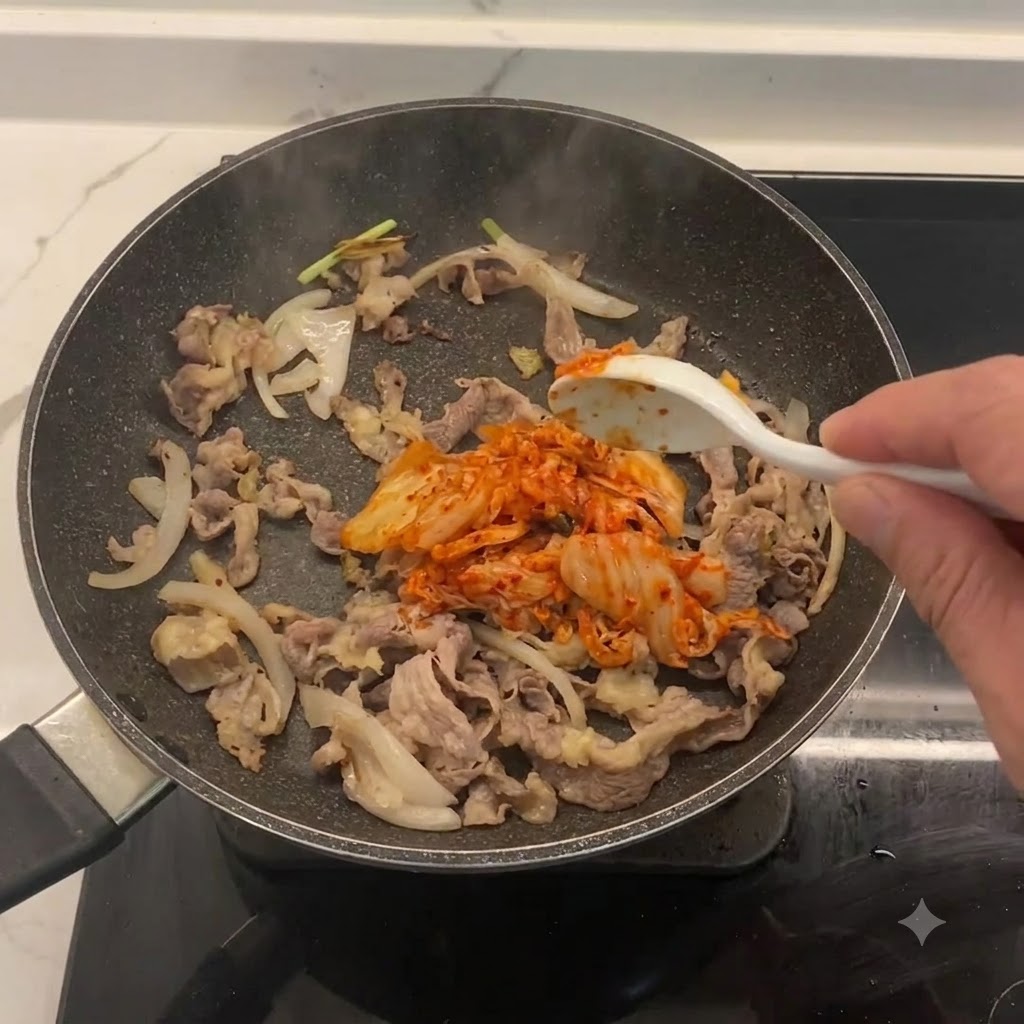 Kimchi haché mélangé dans la poêle avec le bœuf et les oignons.