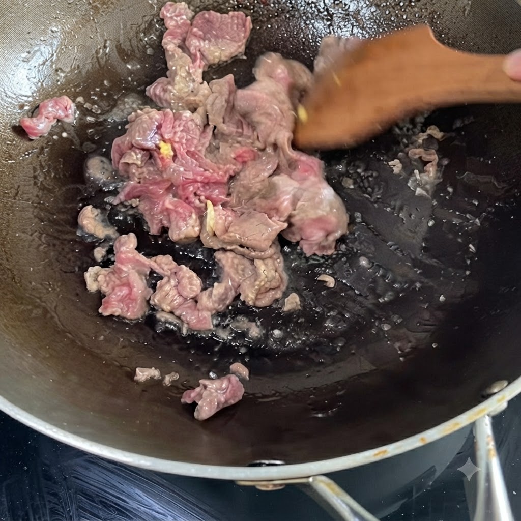 Du bœuf mariné grésillant et sauté dans un wok chaud à laide dune spatule en bois.