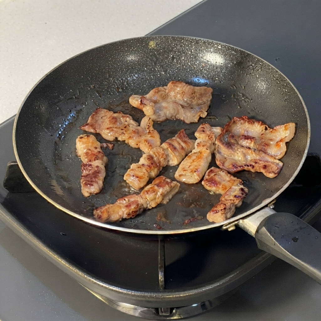 Tranches de bœuf cuites coupées en morceaux plus petits avec des ciseaux de cuisine directement dans une poêle.