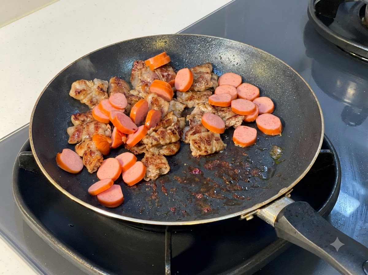 Saucisses tranchées ajoutées dans la poêle contenant les tranches de bœuf cuites.