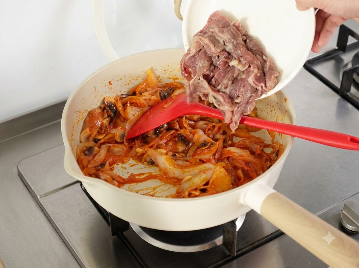 Des tranches de bœuf précuites à leau et un bol de riz cuit de la veille ajoutés dans la poêle.