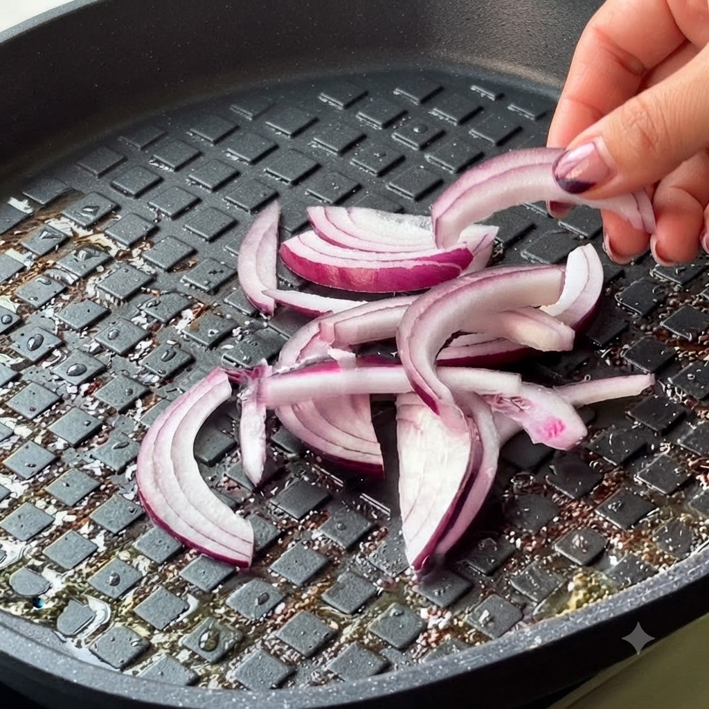 Oignon rouge émincé et kimchi ajoutés dans la poêle.