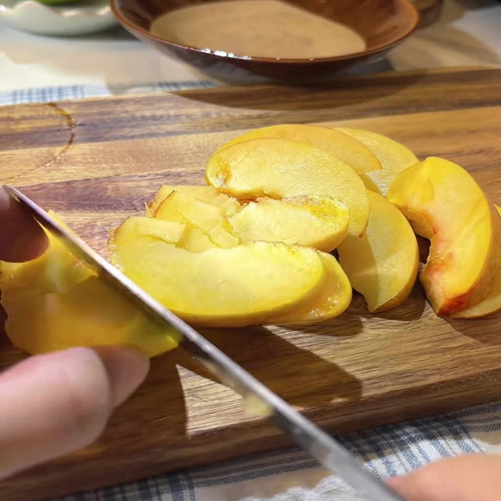 Des graines et de la pulpe de fruit de la passion frais versées à la cuillère sur les pêches jaunes tranchées sur la planche à découper.