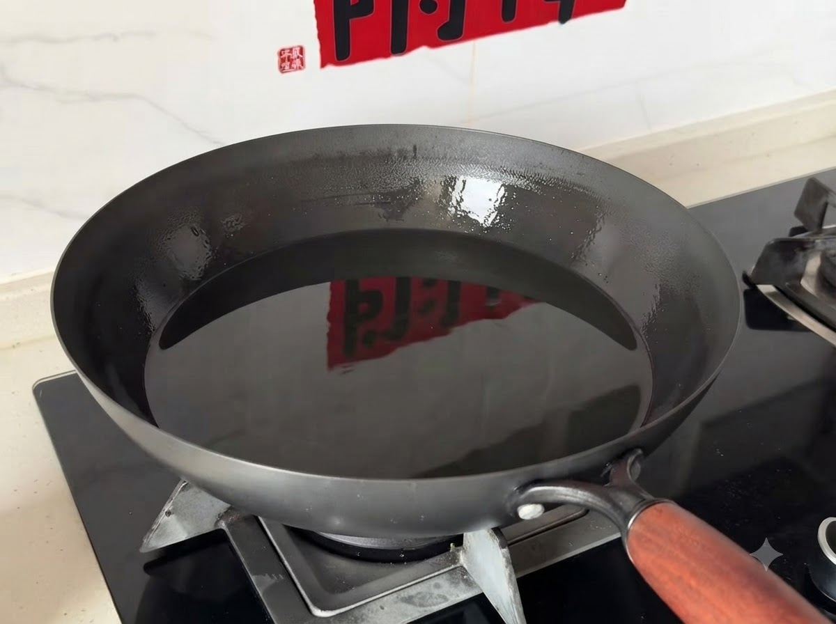 Un wok profond rempli dhuile de cuisson propre posé sur un brûleur de cuisinière à gaz.