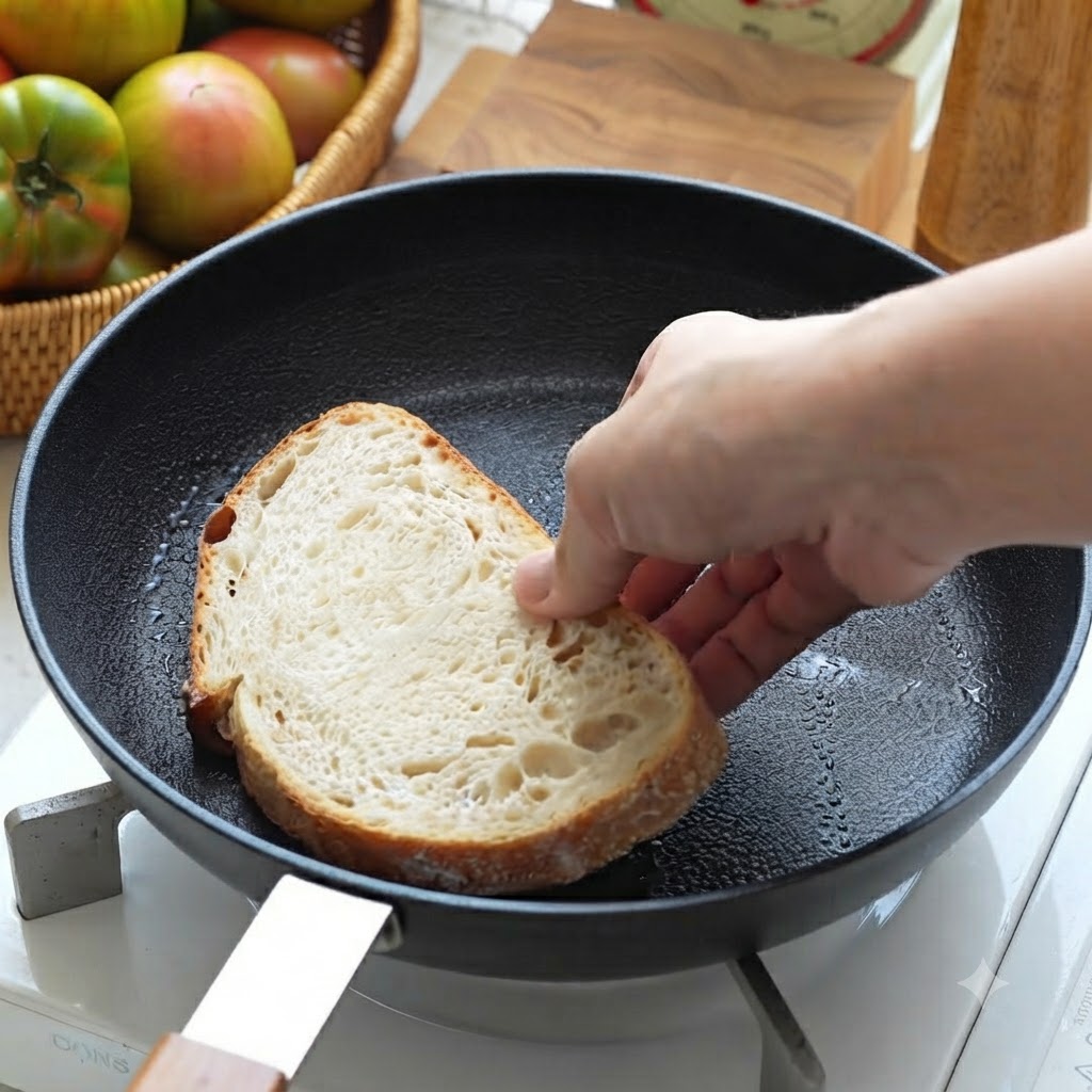 Une tranche de pain au levain placée dans une poêle noire pour être toastée.