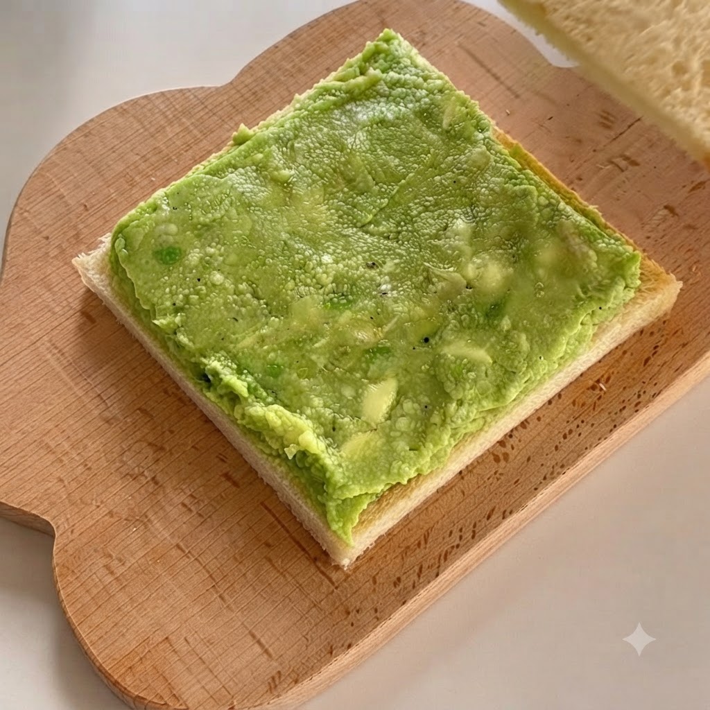 Une seconde tranche de pain de mie placée directement sur la couche supérieure de pâte davocat.