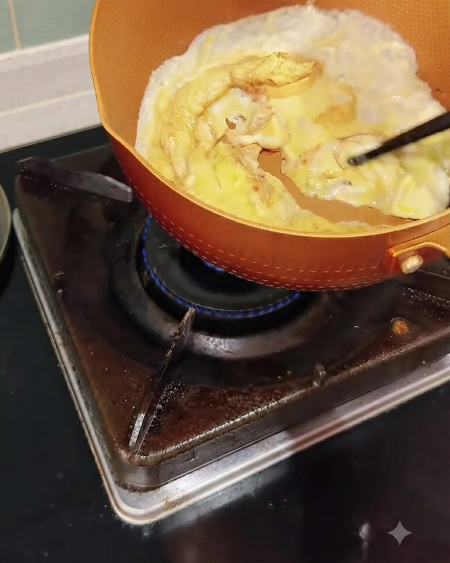 Des œufs cuisant dans une poêle en train dêtre poussés et brouillés délicatement avec des baguettes.