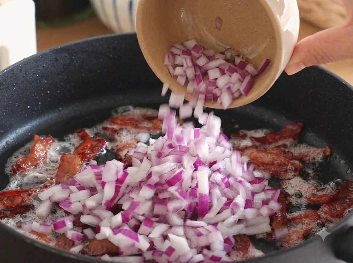 Des oignons rouges coupés en dés versés dans la poêle sur le bacon cuit.