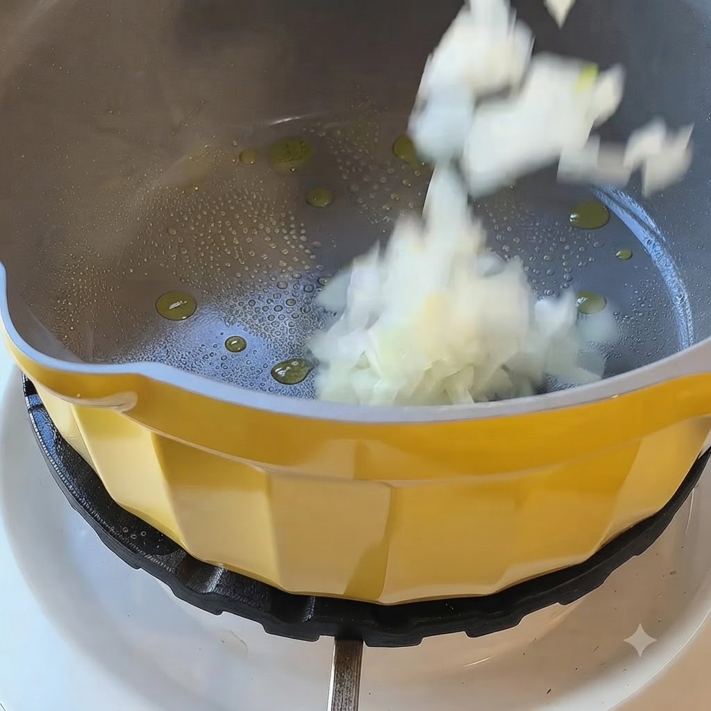 Oignons blancs hachés tombant dans une casserole jaune avec de lhuile chaude sur un feu de cuisinière.