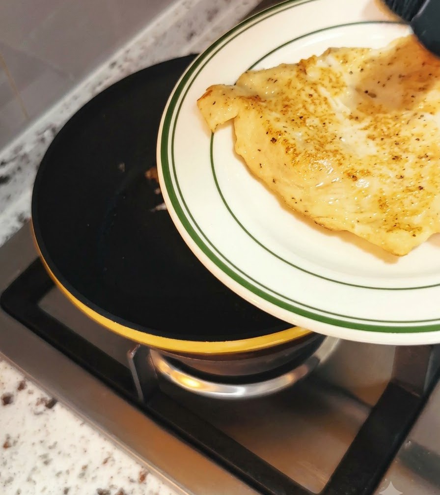 De leau versée dans une poêle autour dun œuf en cuisson avant de couvrir avec un couvercle.