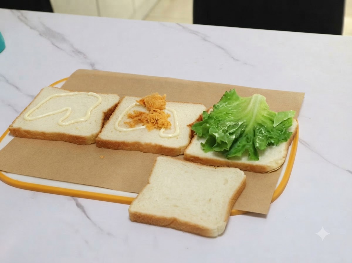 Une portion de porc effiloché transférée avec des pinces sur une tranche de pain recouverte de sauce.