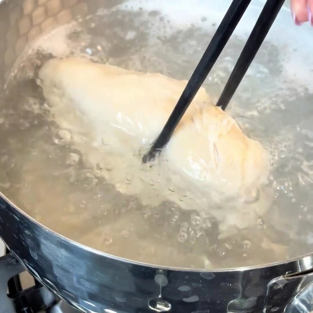 Un blanc de poulet mijotant dans de leau chaude à lintérieur dune casserole.