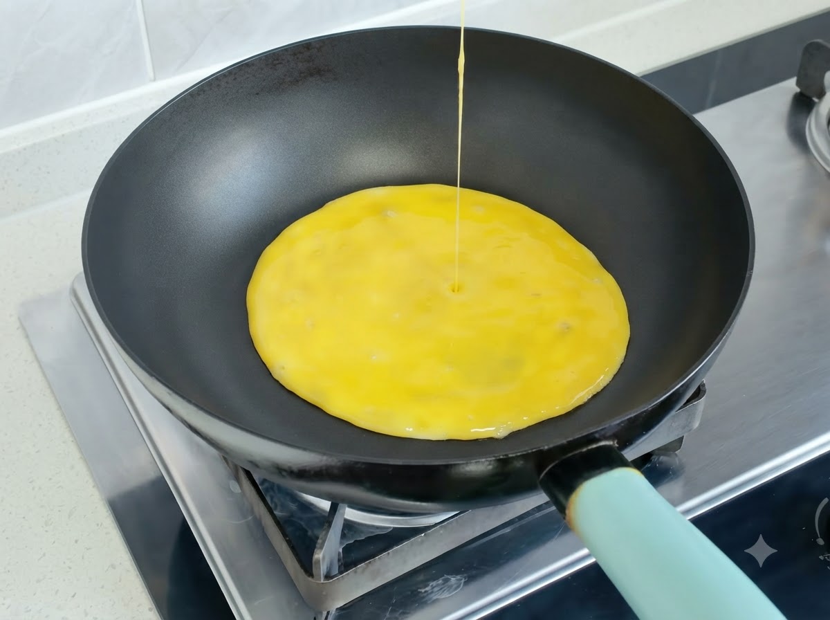 Mélange dœufs battus versé dans une poêle chaude pour former une omelette.