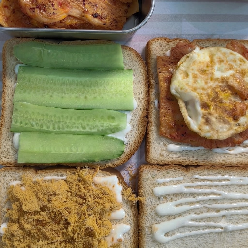 Une tranche de pain de mie avec une garniture blanche surmontée dun morceau de poulet assaisonné et dun œuf au plat.