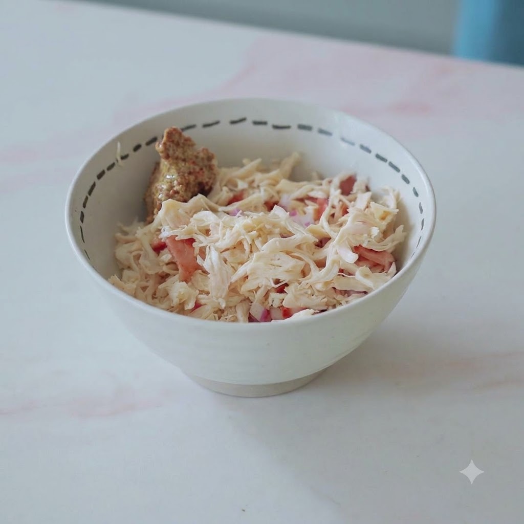 Un bol rempli de poulet effiloché, de bacon, doignons et dune noisette de moutarde prêts à être mélangés.