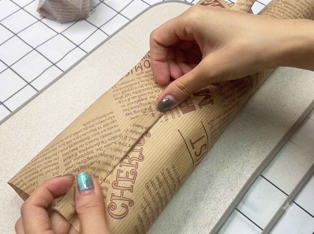 Un sandwich fraîchement préparé emballé hermétiquement et solidement dans du papier sulfurisé marron décoratif.