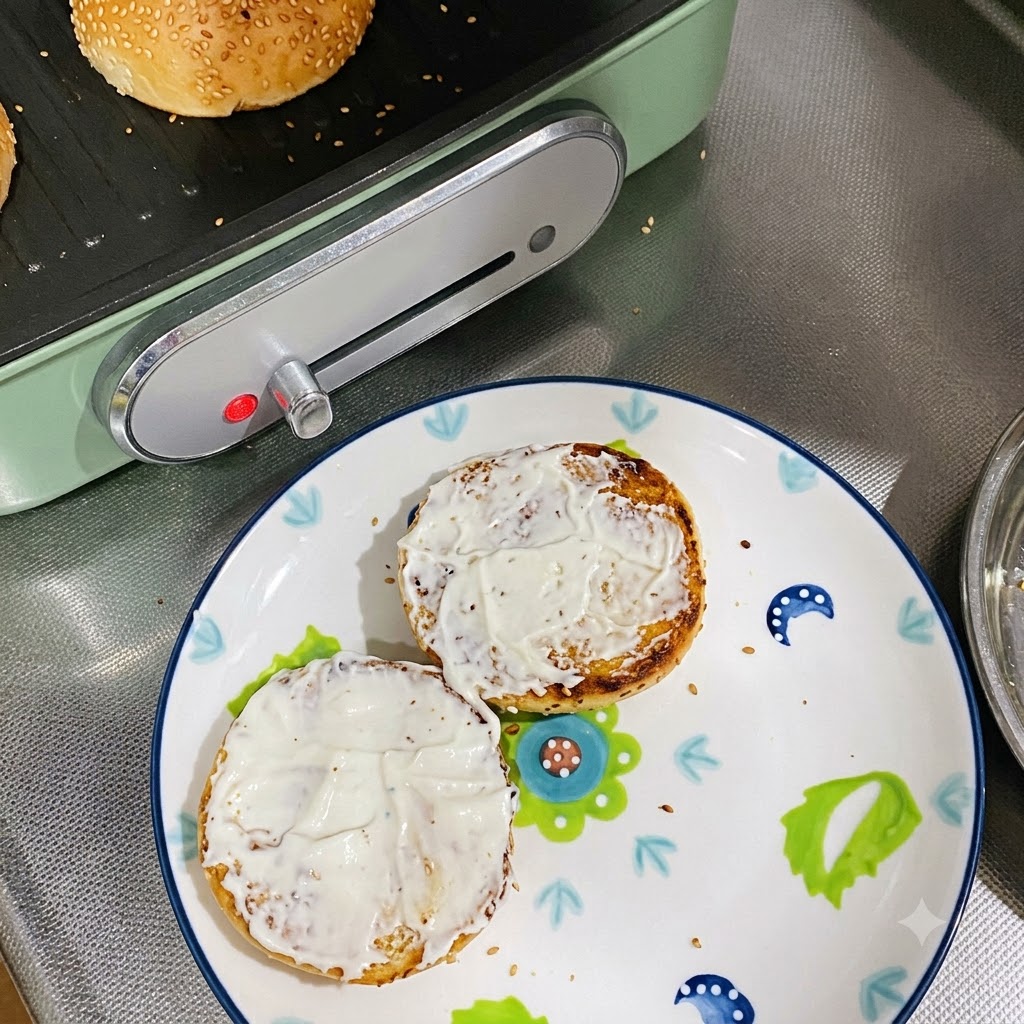 Deux moitiés de pain toastées et garnies de mayonnaise posées sur une assiette décorée.