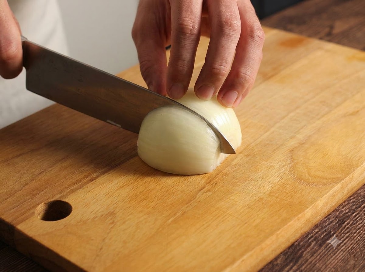 Un oignon coupé avec soin et émincé sur une planche à découper en bois à laide dun couteau de cuisine.