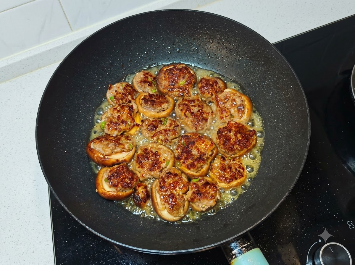 De leau versée dans le wok autour des champignons et de la viande poêlés.