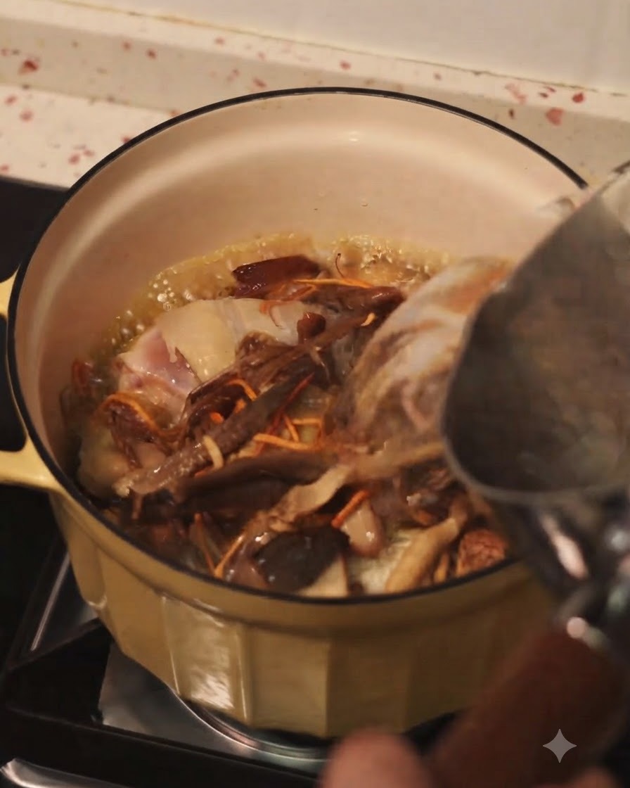 Versement deau chaude dune bouilloire dans une casserole de poulet sauté et de champignons assortis.