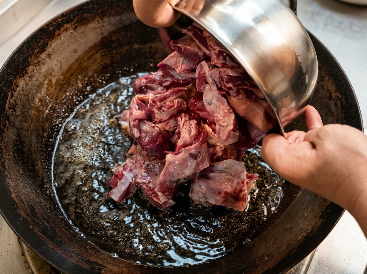 De grands morceaux de bavette de bœuf ajoutés dans leau dun wok.