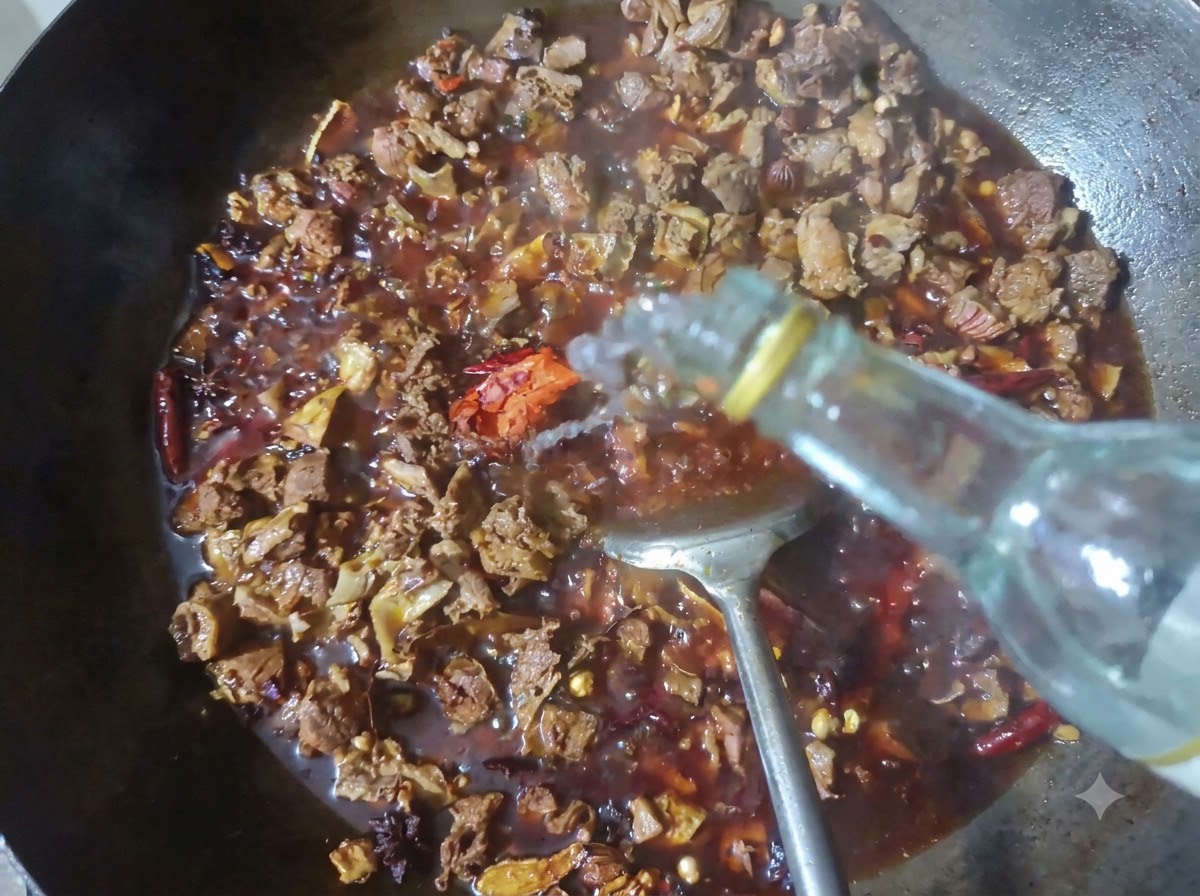 Une bouteille versant du baijiu clair dans un wok rempli de bœuf braisé et dépices.