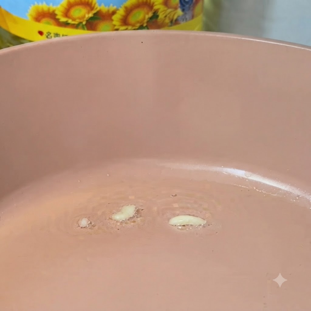 Ail émincé en train de frire dans une poêle rose chaude avec de lhuile.