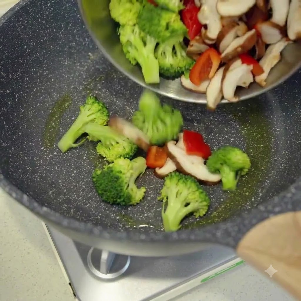 Des légumes fraîchement tranchés versés dun bol dans un wok chaud et huilé.