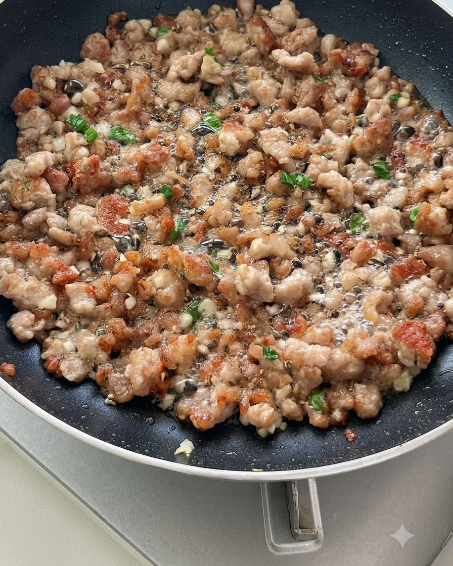 Tomates en tranches sautées avec de la viande hachée et des aromates dans une poêle, commençant à libérer leur jus.