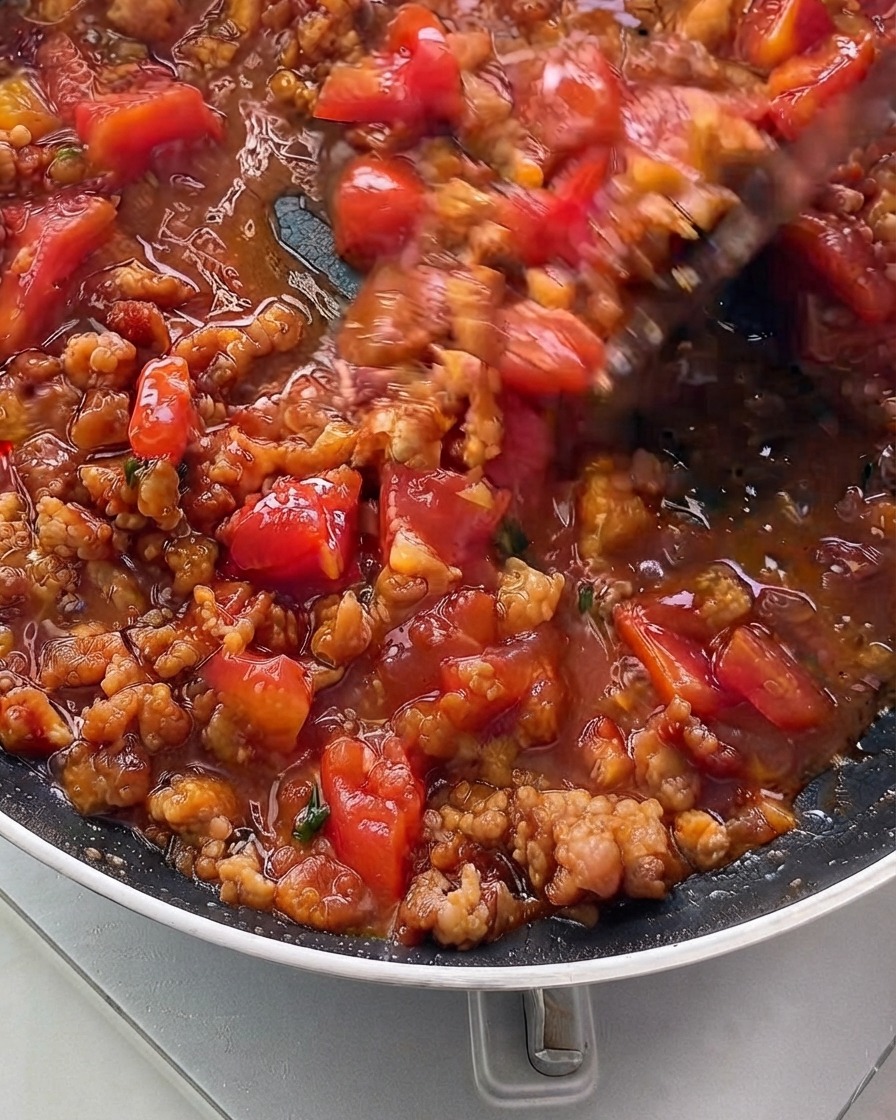 Le mélange de sauce mijotant et épaississant dans une poêle.