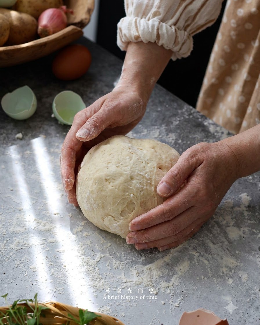 Mains formant et pétrissant délicatement la pâte à gnocchi en boule sur une surface farinée.