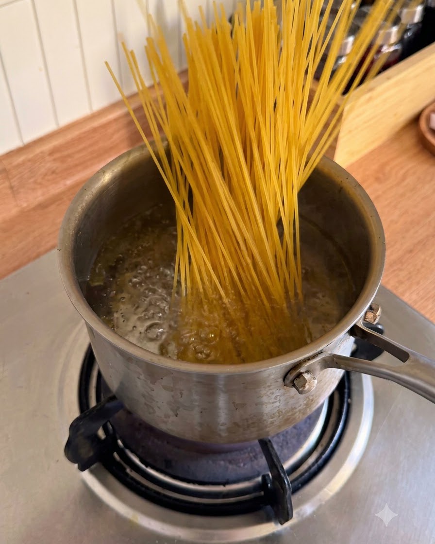 Bâtonnets de spaghettis secs insérés dans une casserole deau bouillante bouillonnante.