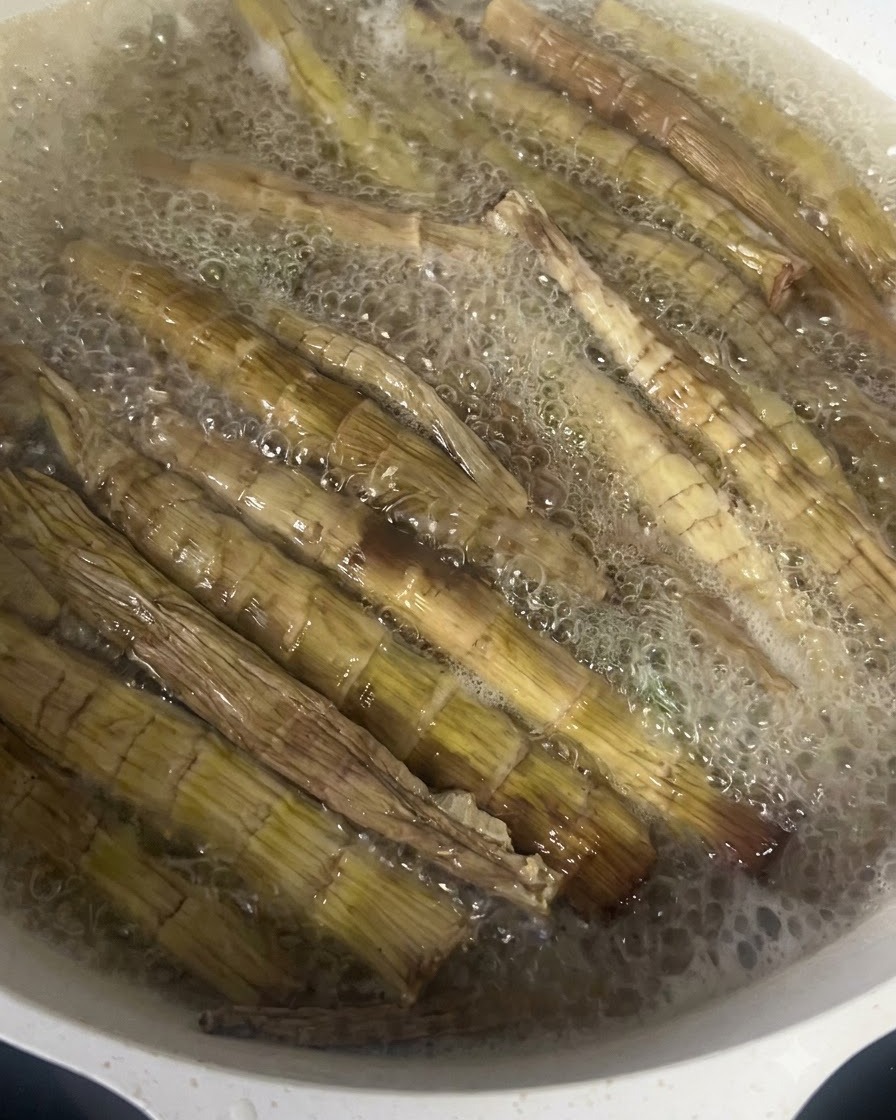 Pousses de bambou séchées bouillant vigoureusement dans une casserole deau chaude.