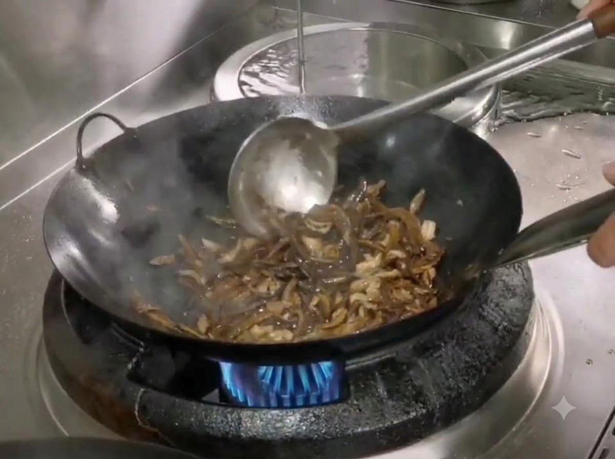 Du sel et du sucre incorporés dans le wok avec les pousses de bambou et le porc émincé à laide dune spatule en métal.