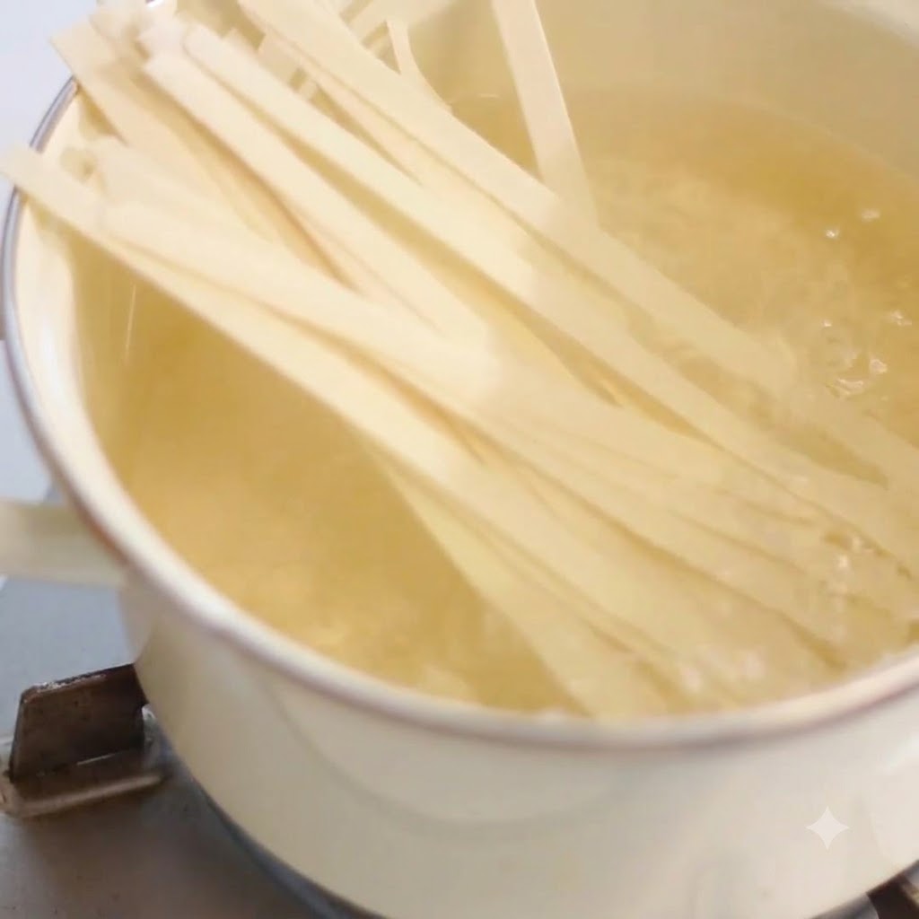Larges nouilles cuisant dans une casserole deau bouillante chaude sur une cuisinière.
