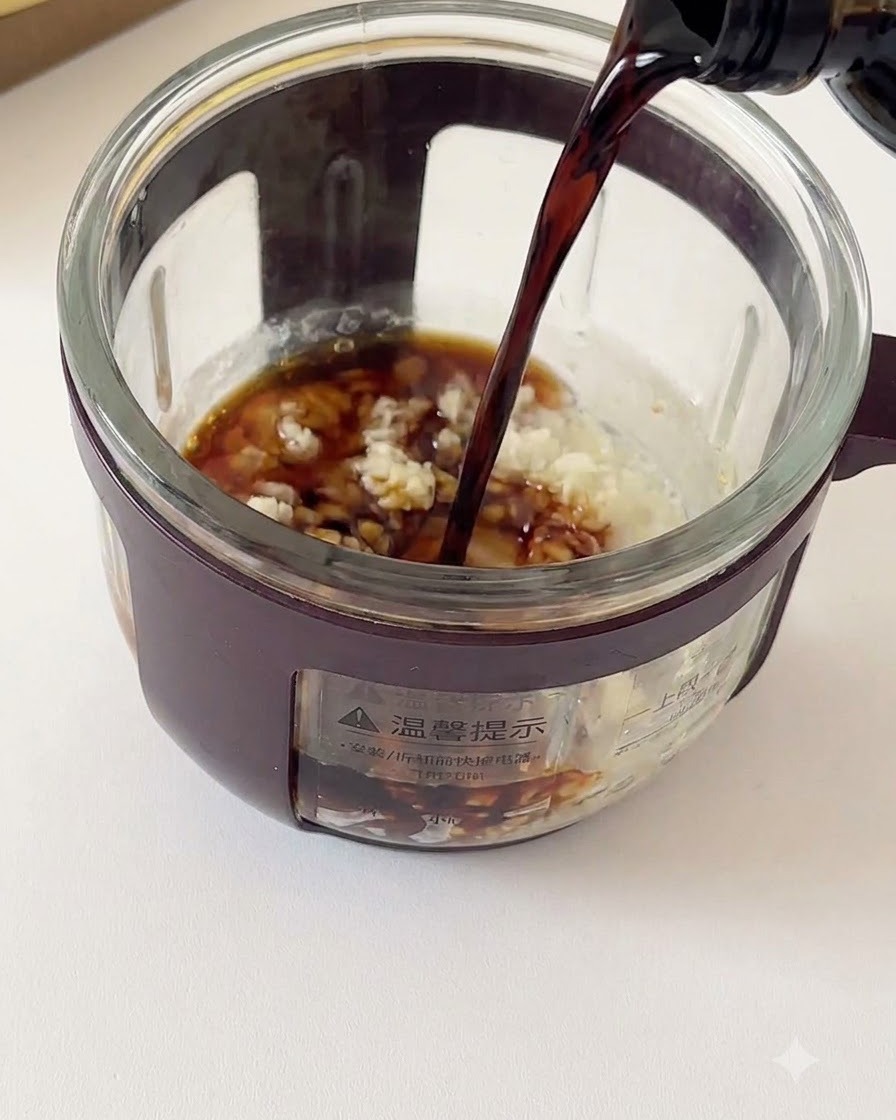 De la sauce soja noire versée dune bouteille dans un récipient en verre rempli dail émincé et dassaisonnements.