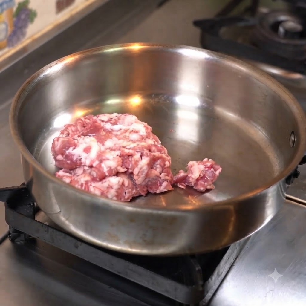 Viande hachée pressée à plat dans une poêle en acier inoxydable pour la cuisson.