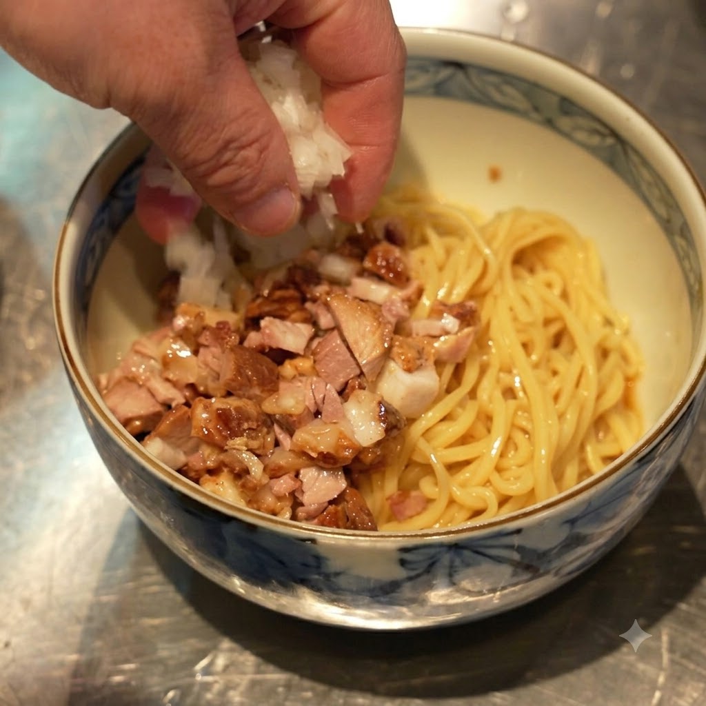Une main saupoudrant des oignons blancs en dés sur le bol contenant les nouilles et le chashu en dés.