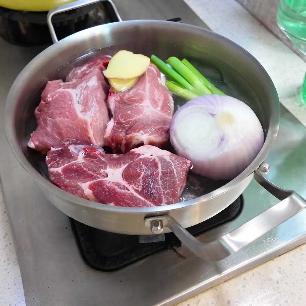 De leau est versée dans une marmite remplie de porc, oignon, gingembre, ciboule et épices.