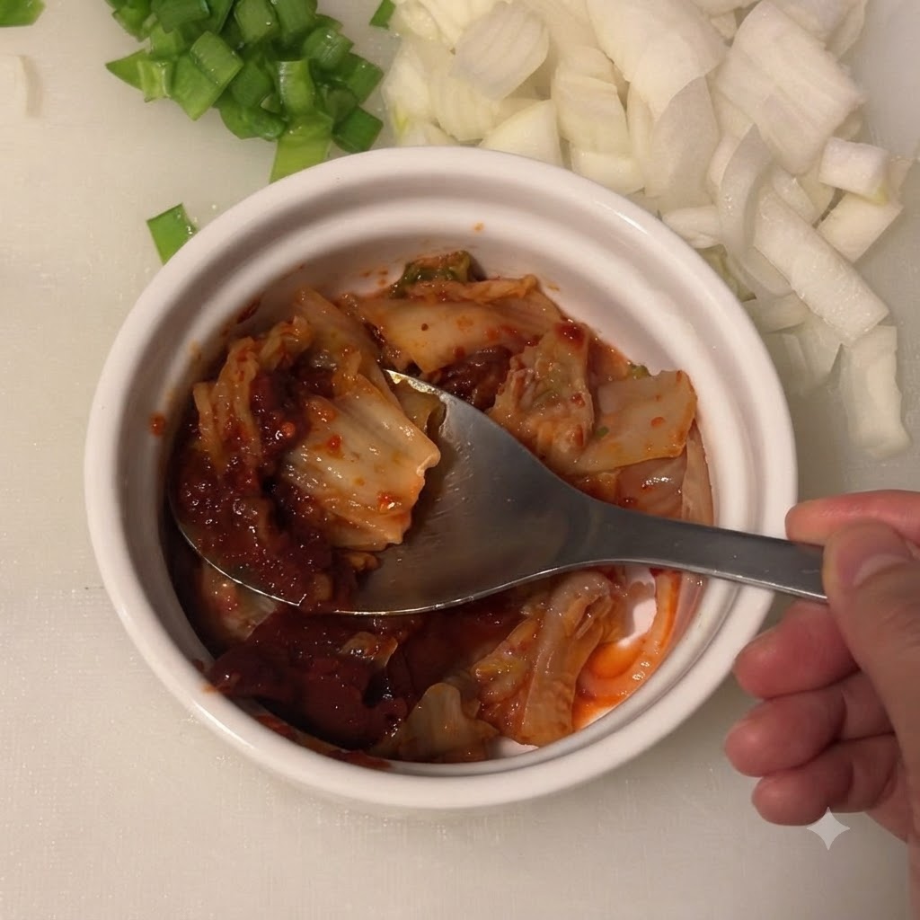 De la sauce soja claire versée dans le bol contenant le kimchi et la pâte de piment coréenne.