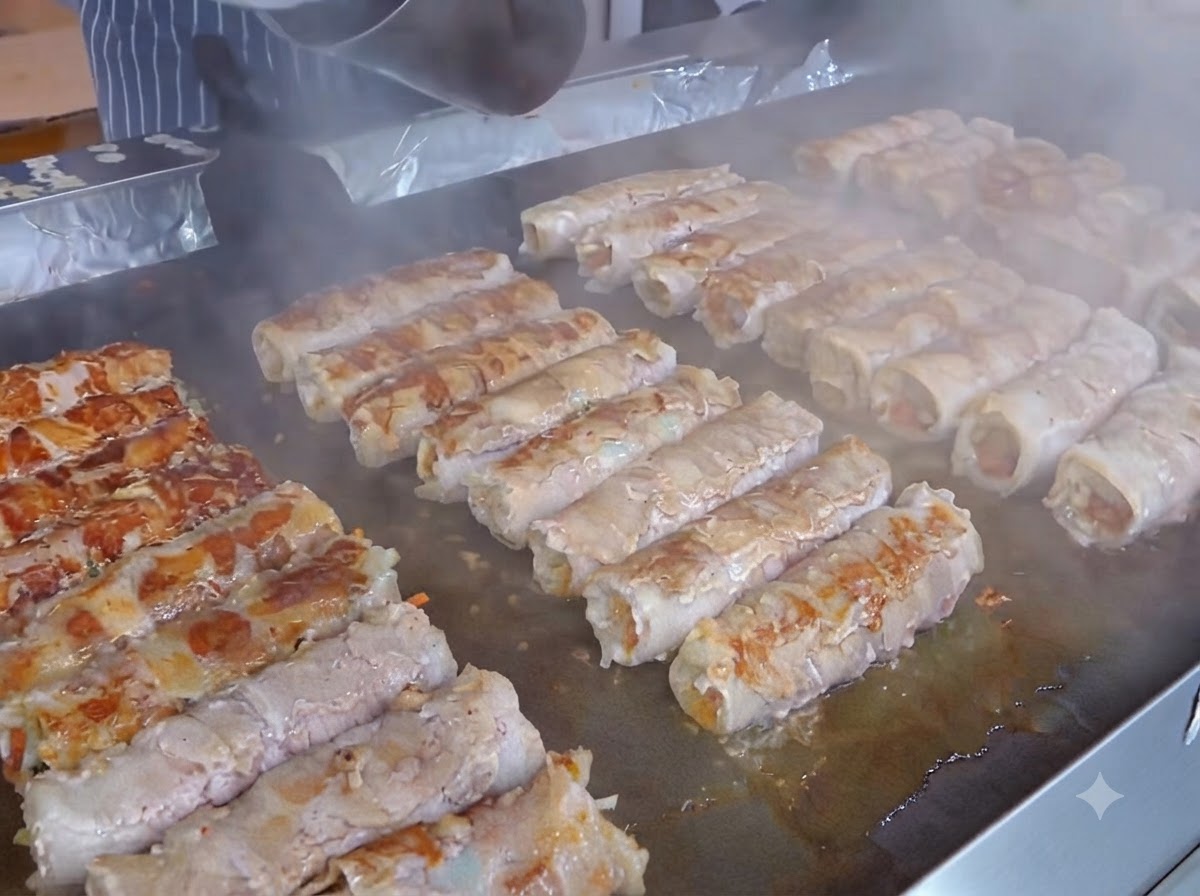 Une tranche de fromage jaune placée sur la couche de kimchi des rouleaux de viande préparés.