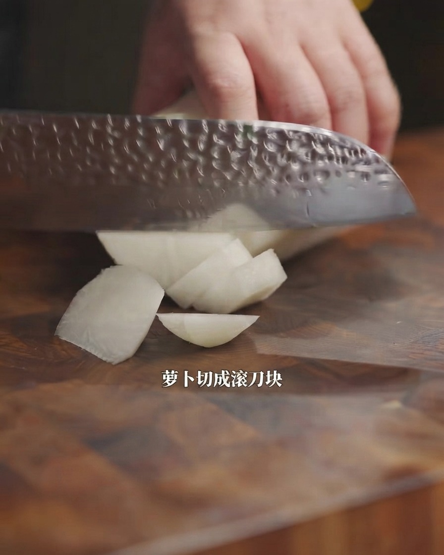 Un couteau de cuisine coupant un radis blanc en morceaux sur une planche en bois.