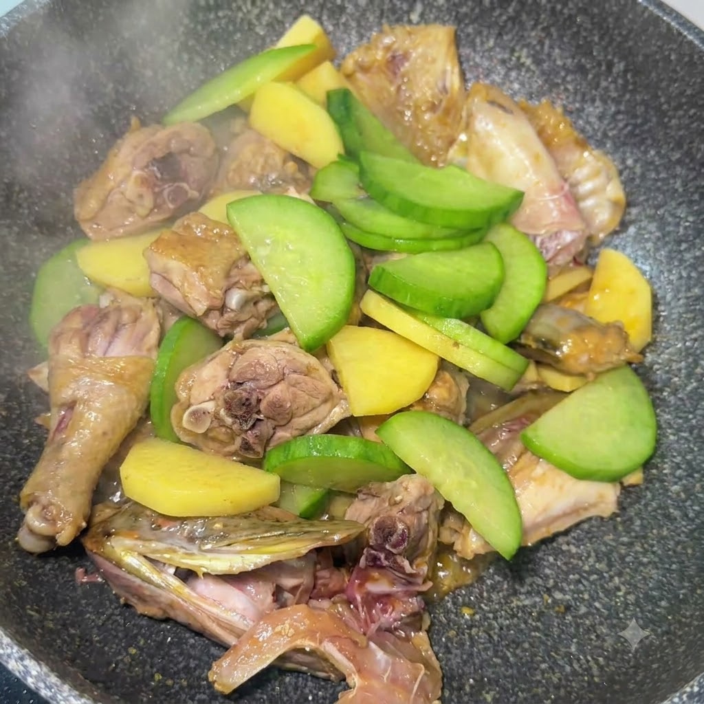 Tranches de radis vert mélangées aux pommes de terre et aux morceaux de poisson en train dêtre sautées dans la poêle.
