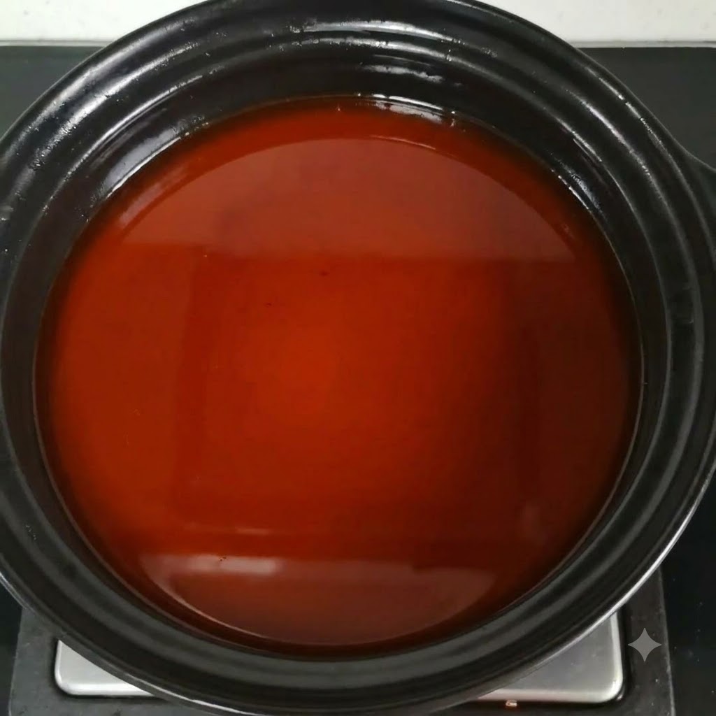 De la sauce nuoc-mâm incorporée au bouillon de soupe brun-rougeâtre dans la casserole.