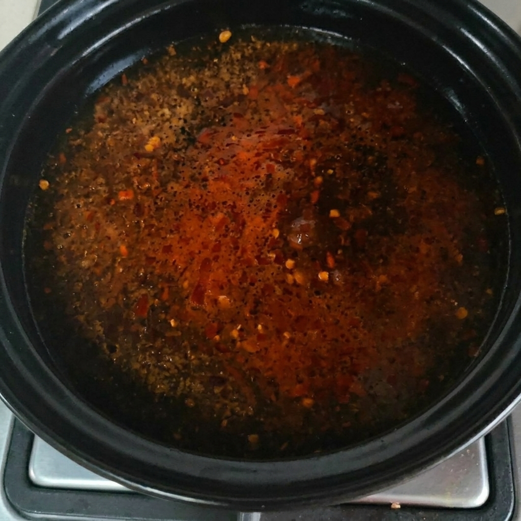 Du bouillon de bœuf en poudre saupoudré à la surface de la soupe frémissante.