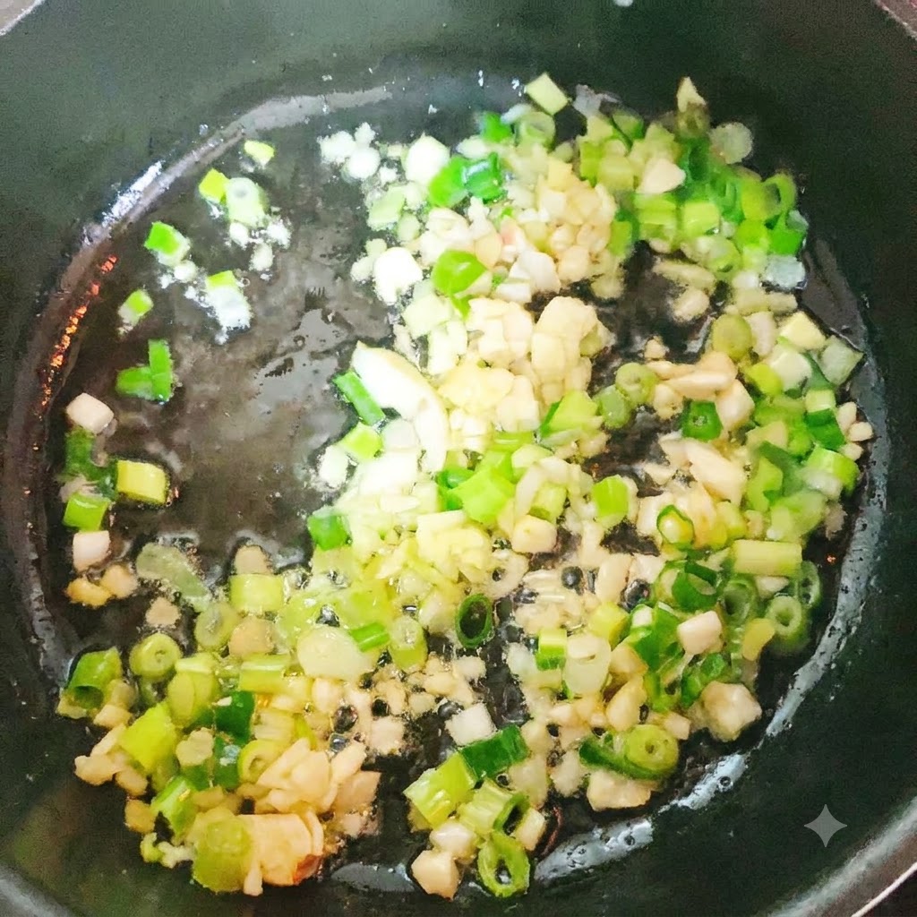 Tête et queue de colin en train de sauter dans une casserole avec des aromates.